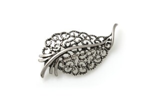 Stylowa brosza w kształcie liścia, wykonanego ze stopu nieszlachetnych metali w kolorze starego srebra
