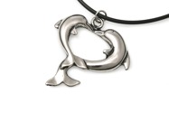 Uroczy wisiorek w postaci dwóch złączonych delfinów, wykonanych ze stopu metali nieszlachetnych, w kolorze srebrnym