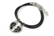 Dwie bransoletki wykonane z czarnego kauczuku, z regulowanym obwodem, z dwiema przywieszkami w kształcie połówek serca, wykonanymi z metalu nieszlachetnego w kolorze srebra, pokryte czarną emalią