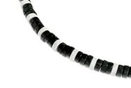 Naszyjnik złożony z czarnych i białych koralików zawieszonych na elastycznej gumce