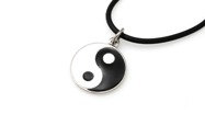Wisiorek wykonany z metalu koloru srebrnego z emaliowanym wypełnieniem, przedstawiającym symbol równowagi Yin Yang