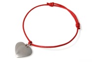 Urocza bransoletka wykonana z czerwonego sznurka jubilerskiego, z przywieszonym serduszkiem w kolorze srebrnym, wykonanym ze stopu metali nieszlachetnych