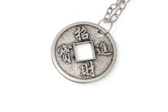Orientalny wisiorek - amulet, w kształcie chińskiej monety z otworem, wykonany ze stopu nieszlachetnych metali w kolorze starego srebra, zawieszony na długim łańcuszku