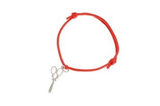 Bransoletka wykonana z czerwonego sznurka jubilerskiego, z przywieszką w kształcie nożyczek, wykonanych ze stopu metali nieszlachetnych w kolorze srebrnym