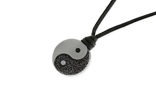 Czarny wisiorek wykonany z woskowanego sznurka jubilerskiego z okrągłą zawieszką, wykonaną z metalu nieszlachetnego w kolorze stalowym w postaci symbolu Yin Yang