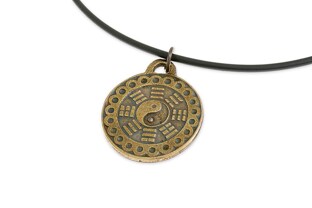 Wisiorek wykonany z gumowego rzemyka z okrągłą zawieszką, wykonaną z metalu nieszlachetnego w kolorze starego złota
 z wypełnieniem w postaci symbolu Yin Yang