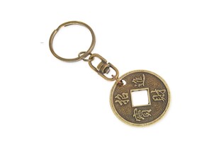 Orientalny breloczek - amulet, w kształcie chińskiej monety z otworem, wykonany ze stopu nieszlachetnych metali w kolorze starego złota zamocowany za pośrednictwem obrotowego łącznika do mocnego zapięcia