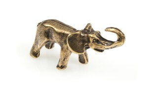 Niewielka figurka słonia z uniesioną trąbą, wykonana z metalu nieszlachetnego w kolorze starego złota