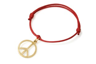 Zawieszka w kształcie ponadczasowego symbolu pokoju, wykonana z metalu nieszlachetnego w kolorze złotym, zawieszona na bawełnianym sznurku jubilerskim w kolorze czerwonym