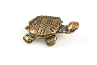 Niewielka zabawna figurka w kształcie żółwia, wykonana z metalu nieszlachetnego w kolorze starego złota