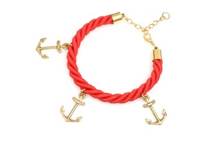 Gruba, czerwona bransoletka wykonana ze sznura imitującego linę żeglarską, z przywieszkami w kształcie kotwiczek