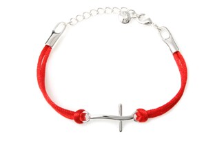 Gustowna bransoletka z czerwonego podwójnego sznurka jubilerskiego, z łącznikiem w kształcie lekko wygiętego krzyżyka, wykonanego z metalu nieszlachetnego w kolorze srebra