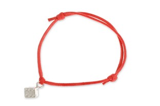 Bransoletka wykonana z czerwonego sznurka jubilerskiego, z przywieszką w kształcie kostki do gry, wykonanej ze stopu metali nieszlachetnych w kolorze srebra