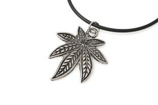 Wisiorek z grawerowanym emblematem liścia marihuany wykonany z metalu w kolorze ciemnego srebra